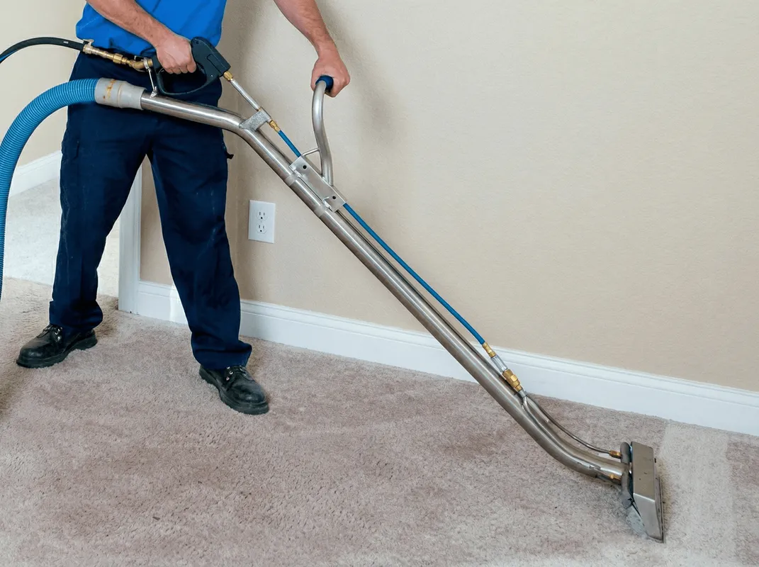 Professional operating a liquid removal machine on a carpeted floor in Fresno, CA
