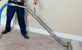 Professional operating a liquid removal machine on a carpeted floor in Fresno, CA